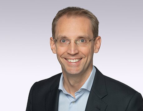 laechelnder-mann-mit-brille-sakko-hemd